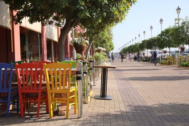 Photo of Beautiful view of outdoor cafe with colorful wooden chairs