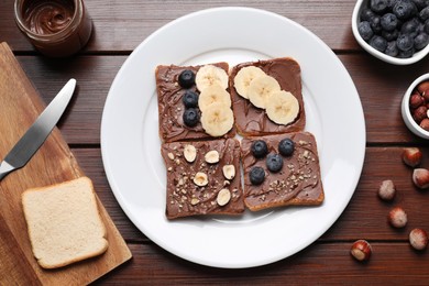 Different tasty toasts with nut butter and products on wooden table, flat lay