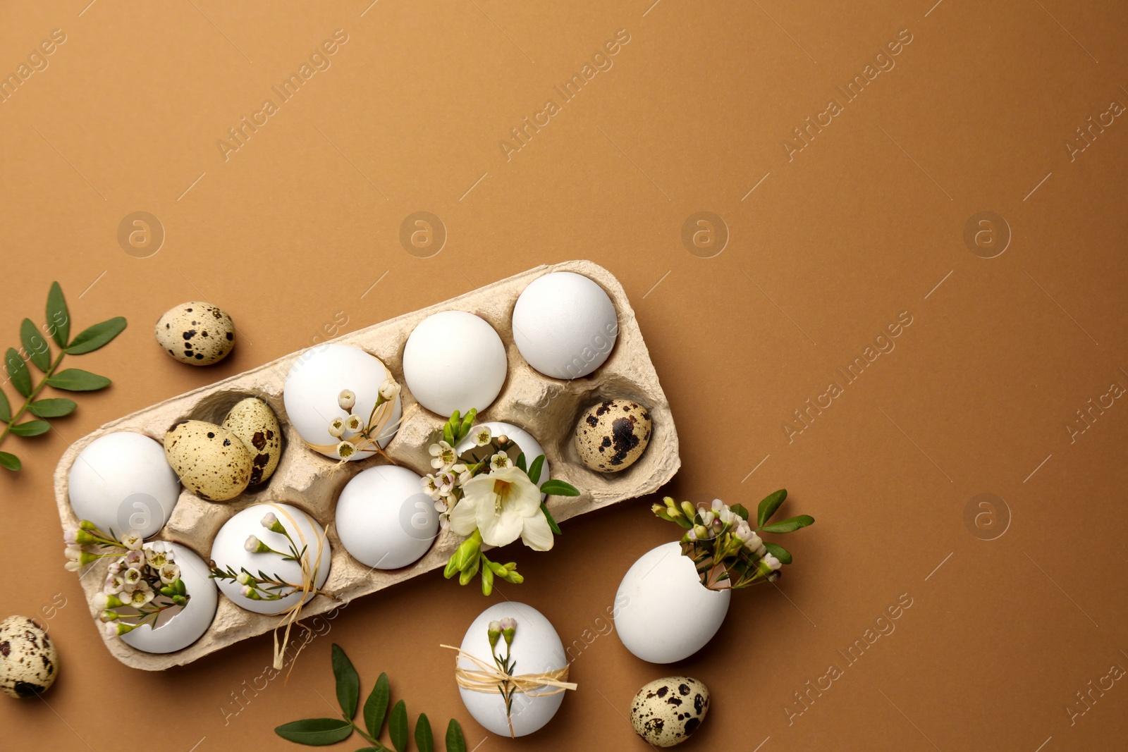 Photo of Happy Easter. Festive composition with eggs and floral decor on brown background, flat lay. Space for text