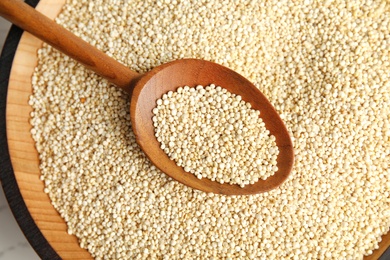 Spoon and bowl with white quinoa, closeup