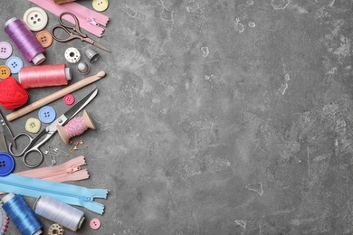 Composition with threads and sewing accessories on grey background, top view