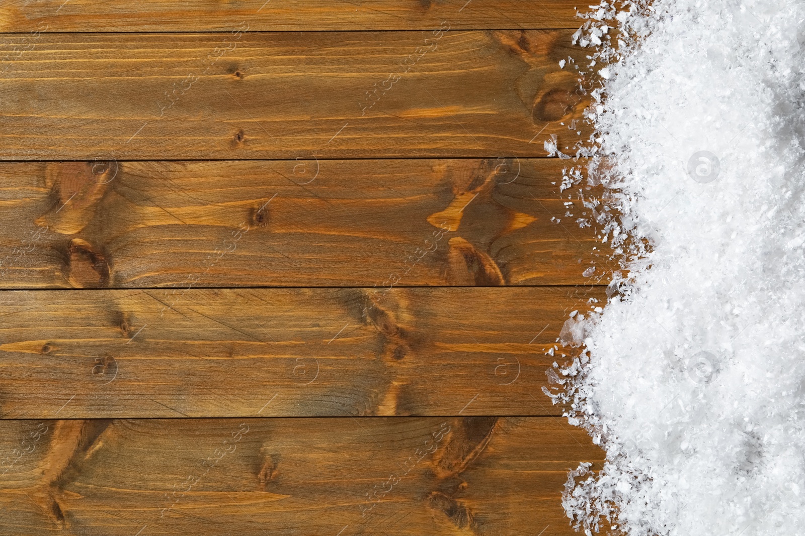 Photo of Snow and space for text on wooden background, top view. Christmas time