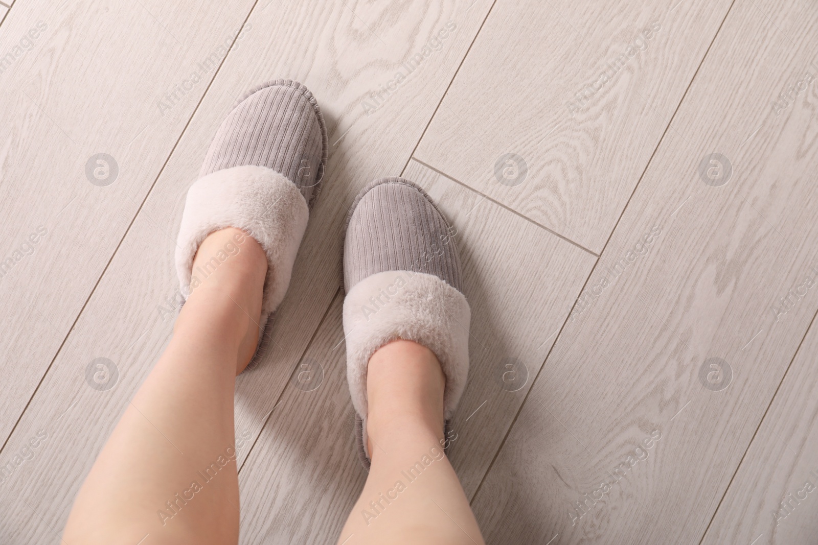 Photo of Woman in warm soft slippers at home, top view. Space for text