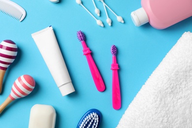 Photo of Flat lay composition with baby toothbrushes and toiletries on color background