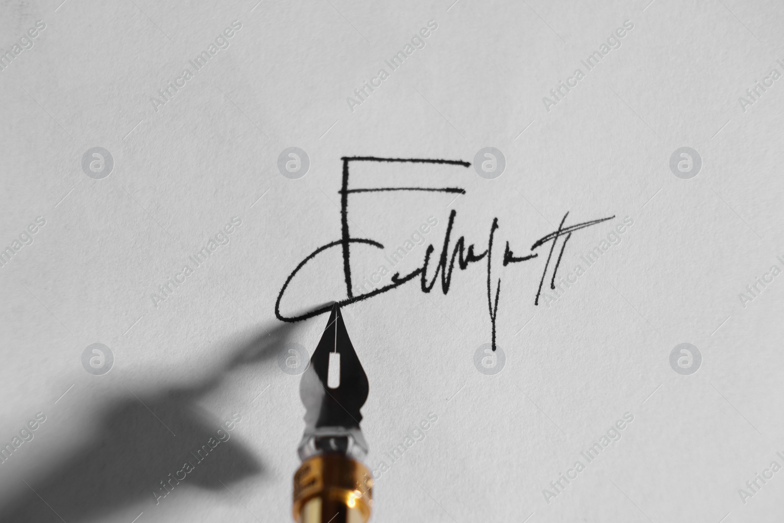 Photo of Signing on sheet of paper with fountain pen, closeup