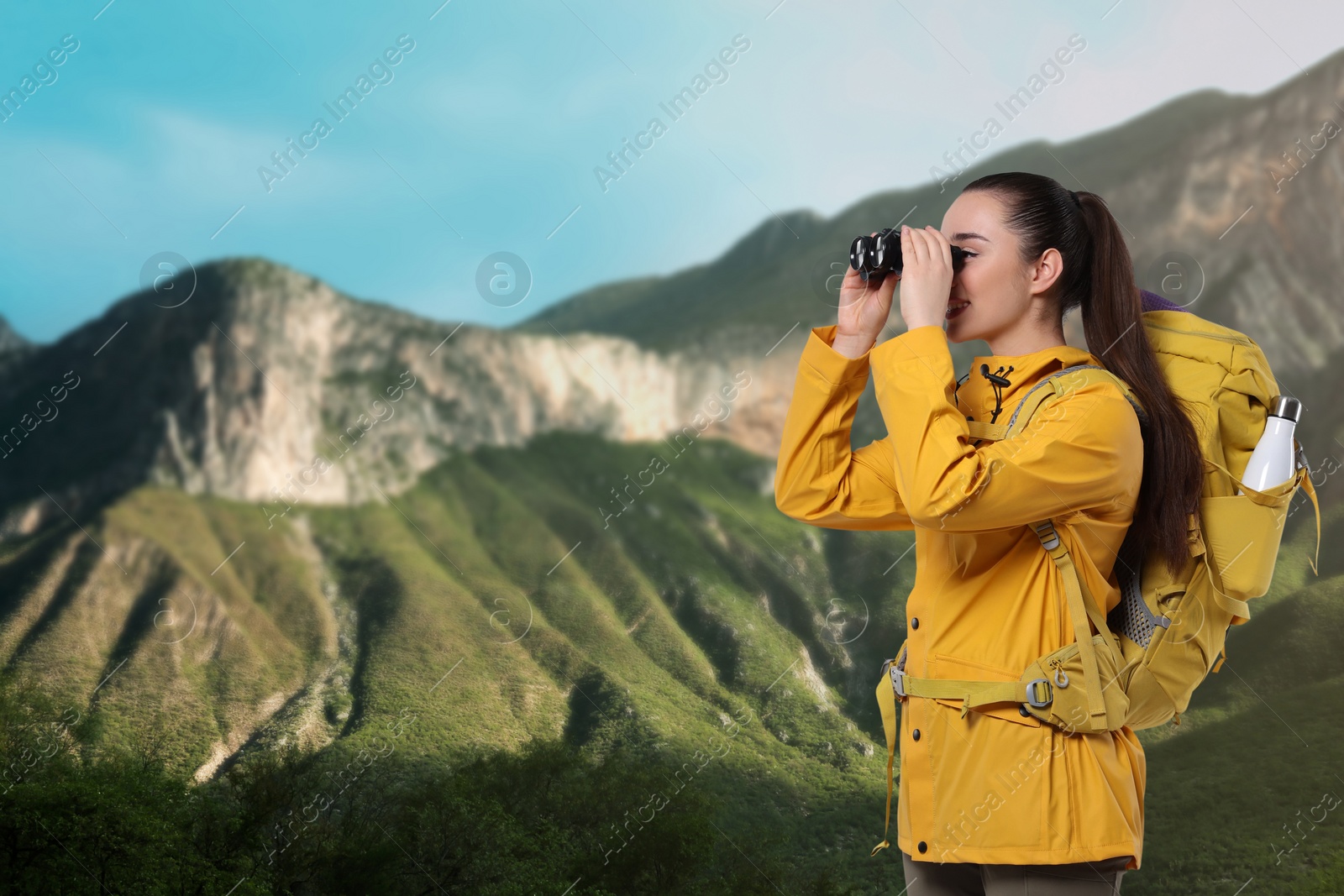 Image of Tourist with backpack and binoculars in mountains