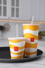 MYKOLAIV, UKRAINE - AUGUST 12, 2021: Cold McDonald's drinks on marble in kitchen