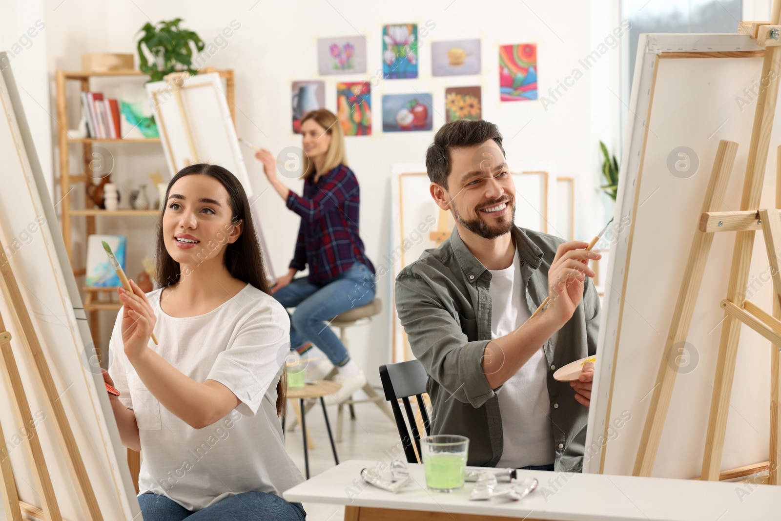 Photo of Group of students attending painting class in studio. Creative hobby