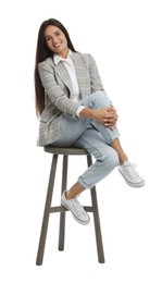 Photo of Beautiful young woman sitting on stool against white background