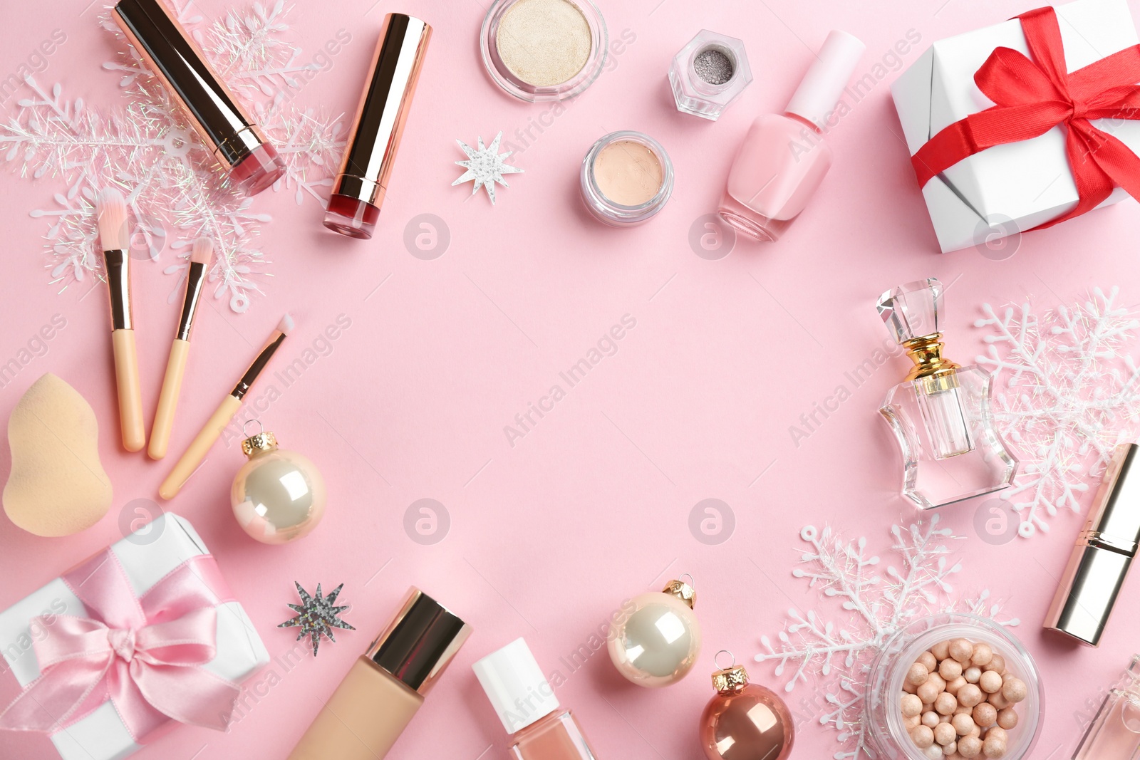 Photo of Frame of decorative cosmetic products on pink background, flat lay with space for text. Winter care