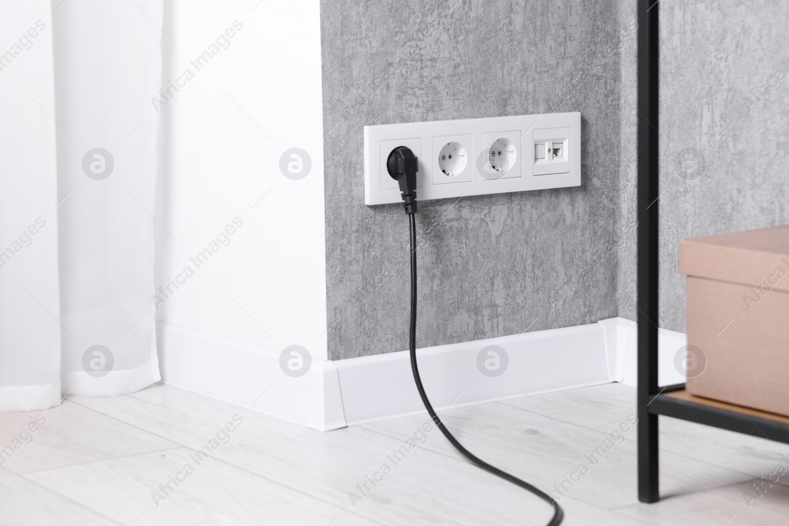 Photo of Power sockets and electric plug on grey wall