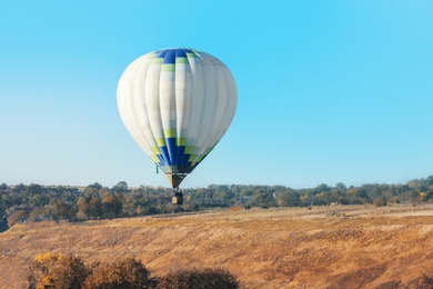 Beautiful view of hot air balloon flying over field