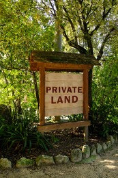 Wooden sign with text Private Land outdoors