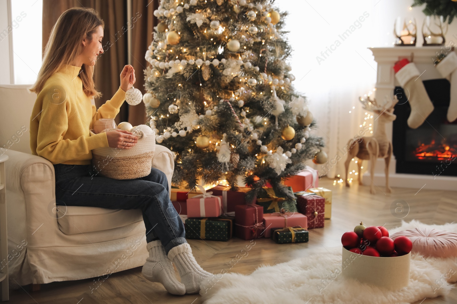 Photo of Beautiful woman decorating Christmas tree at home