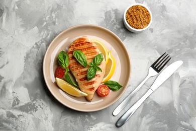 Tasty grilled chicken fillet served on light grey table, flat lay