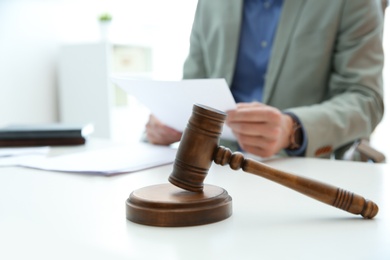 Photo of Notary working at table in office, focus on judge gavel. Law and justice concept