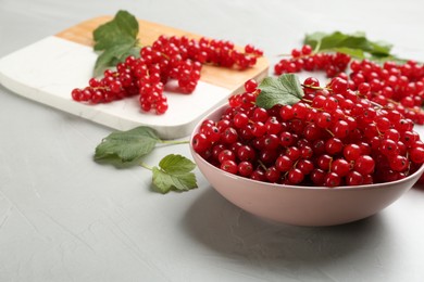Delicious red currants and leaves on light table
