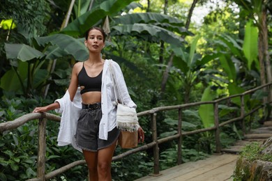 Photo of Beautiful young woman in green tropical park, space for text