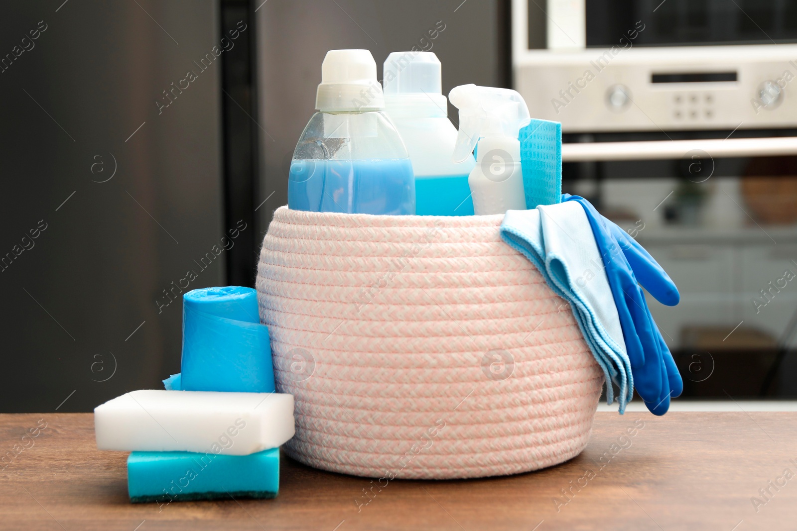 Photo of Different cleaning supplies in basket on table