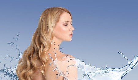 Beautiful young woman and splashing water on blue background. Spa portrait