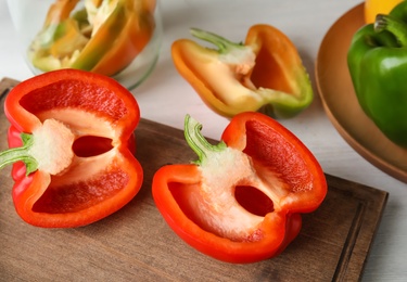 Wooden board with cut paprika pepper on table, closeup