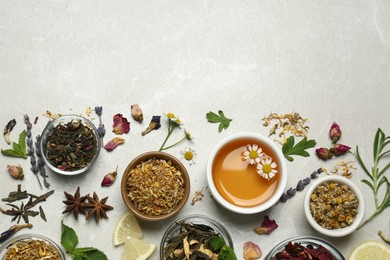 Flat lay composition with fresh brewed tea and dry leaves on light table, space for text