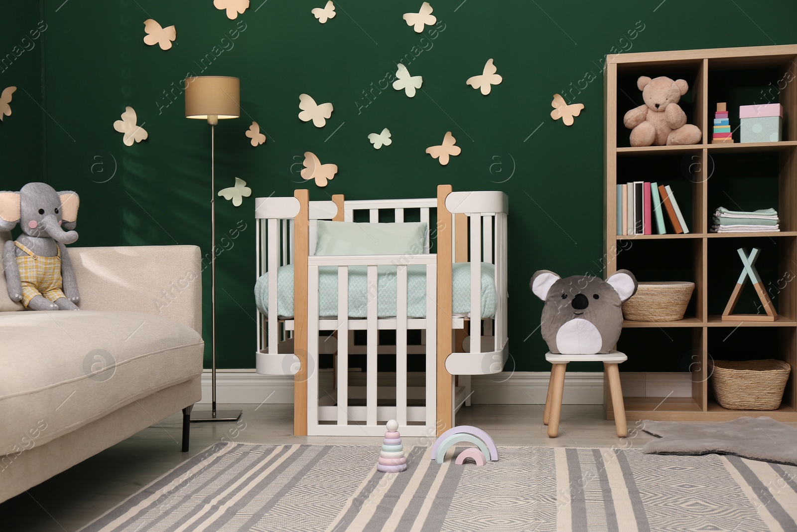 Photo of Beautiful baby room interior with comfortable crib and toys