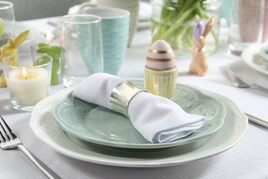 Photo of Easter celebration. Festive table setting with elegant dishware and painted eggs