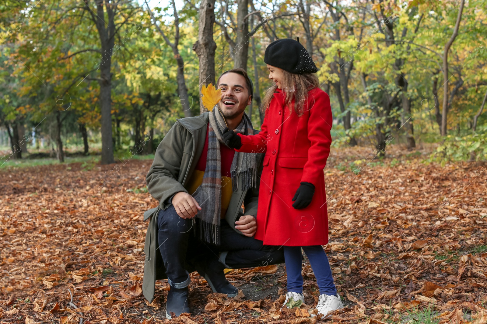 Photo of Father and his cute daughter spending time together in park. Autumn walk