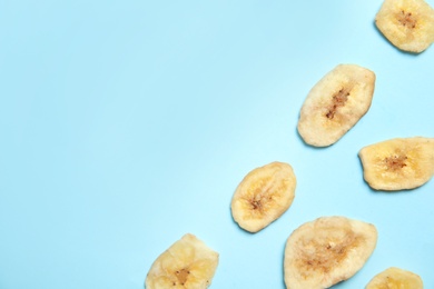 Photo of Flat lay composition with banana slices on color background, space for text. Dried fruit as healthy snack