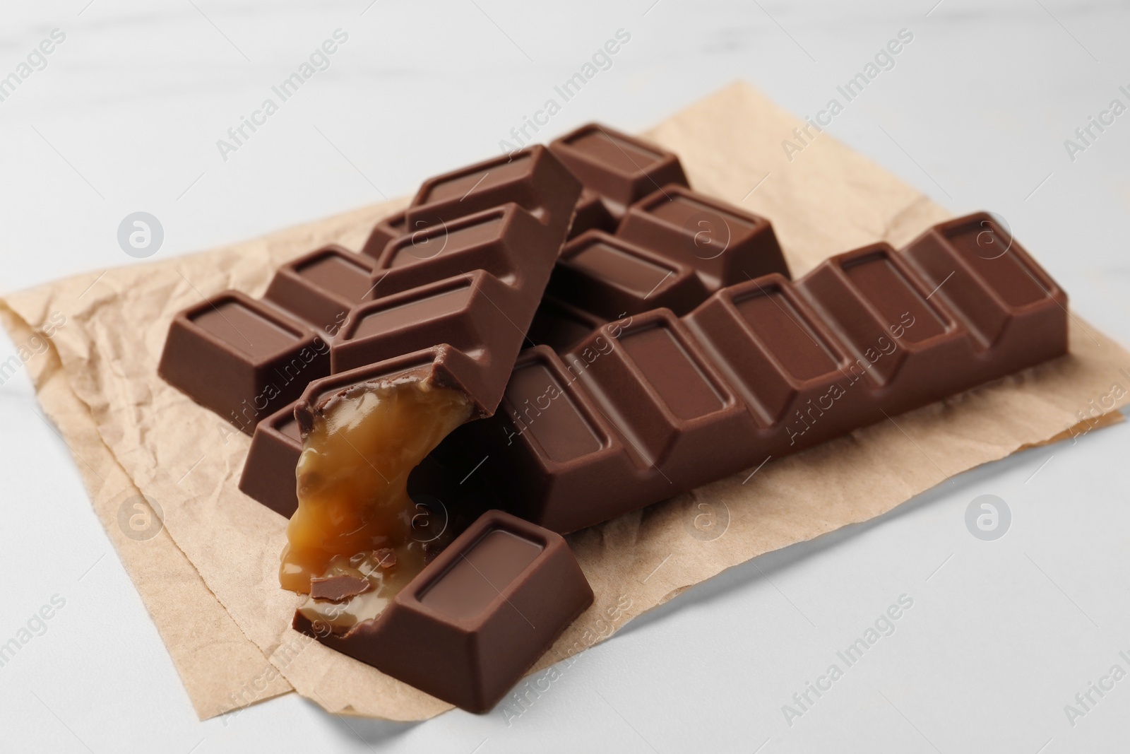 Photo of Tasty sweet chocolate bars on white table