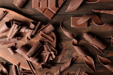 Flat lay composition with chocolate curls on wooden background