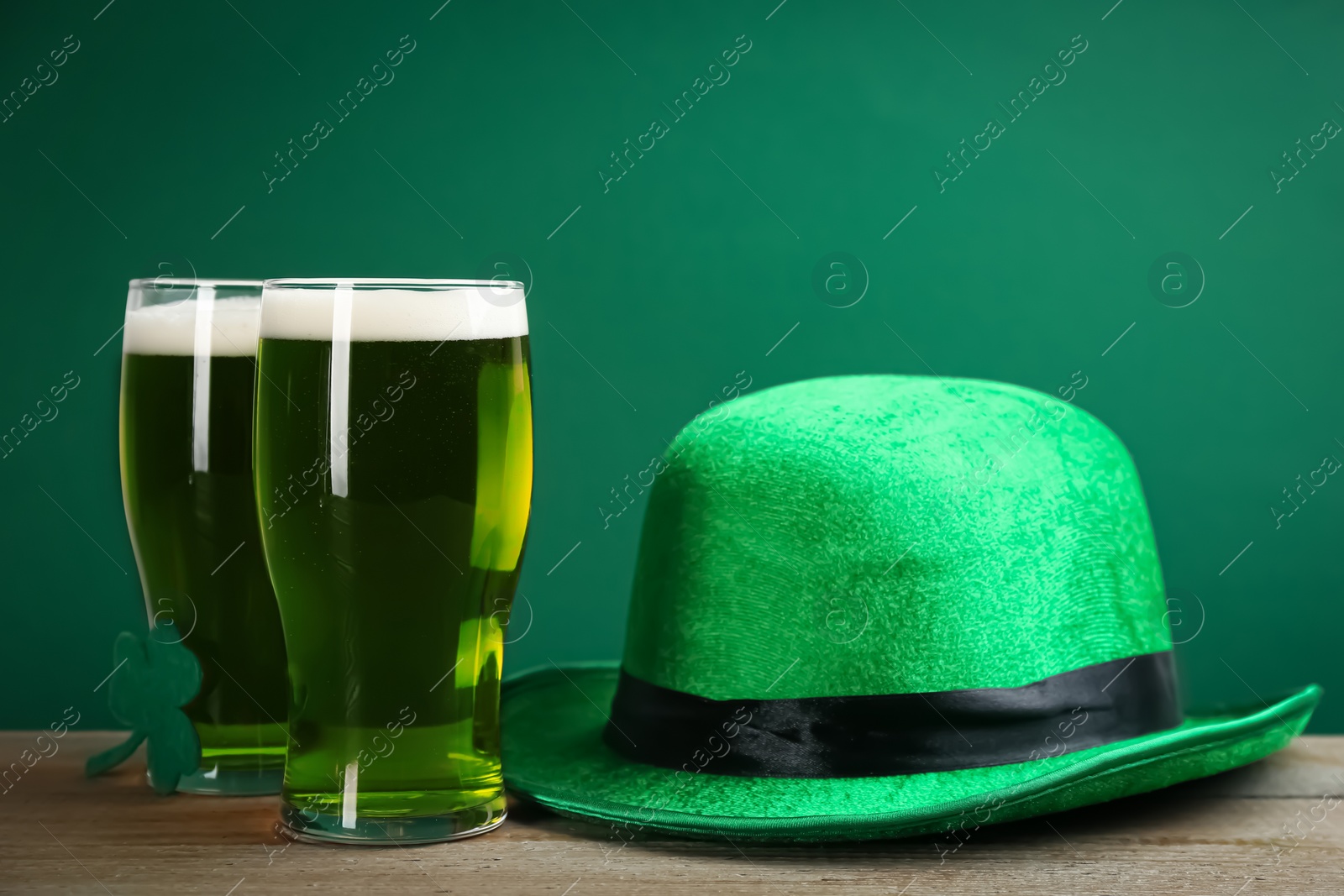 Photo of Green beer and hat on wooden table. St. Patrick's Day celebration