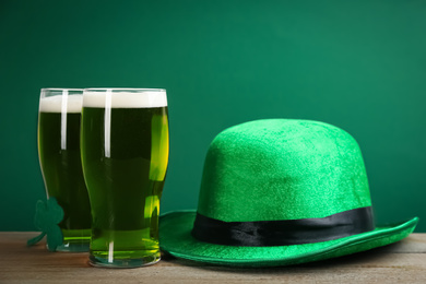 Photo of Green beer and hat on wooden table. St. Patrick's Day celebration