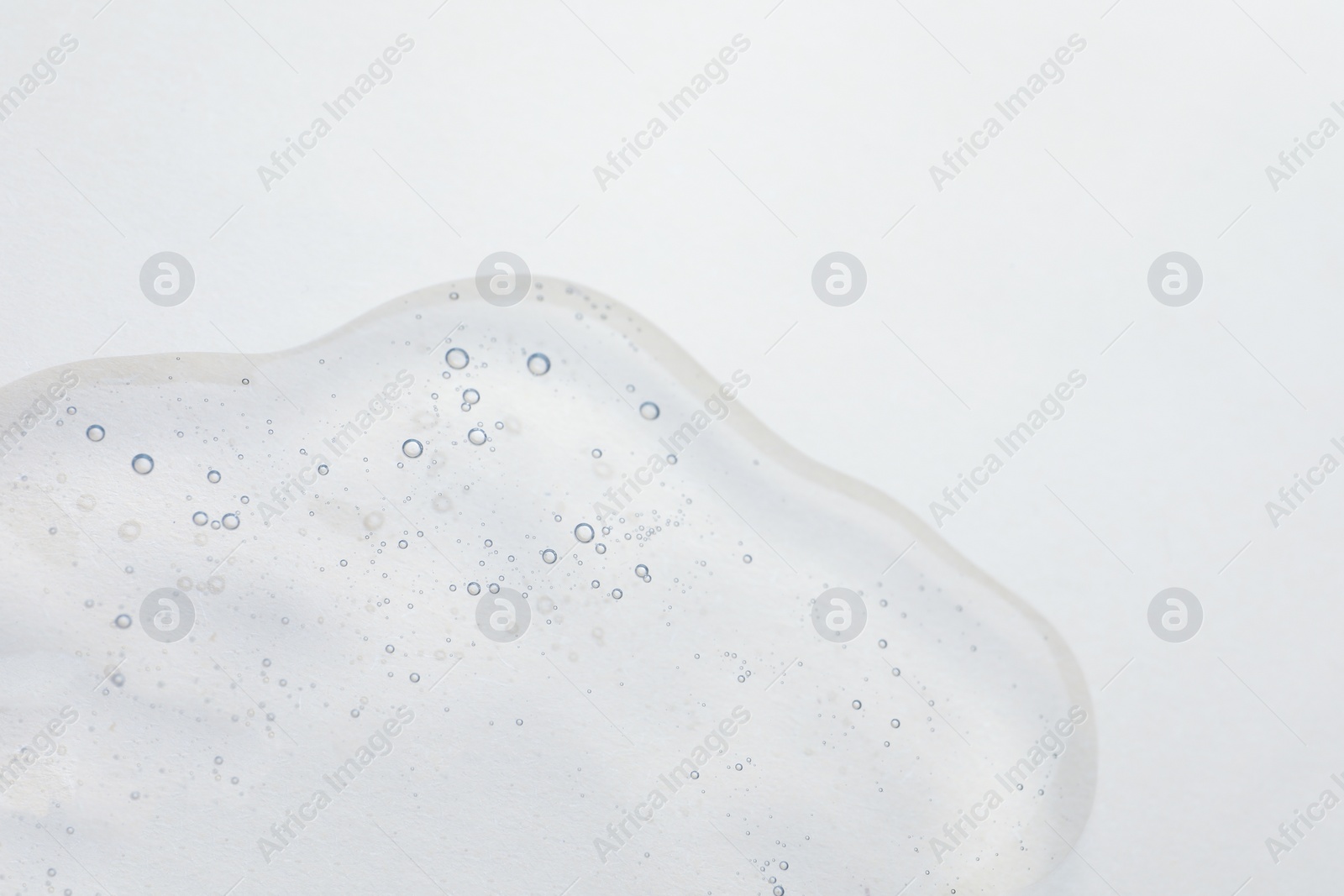 Photo of Sample of cosmetic oil on beige background, closeup