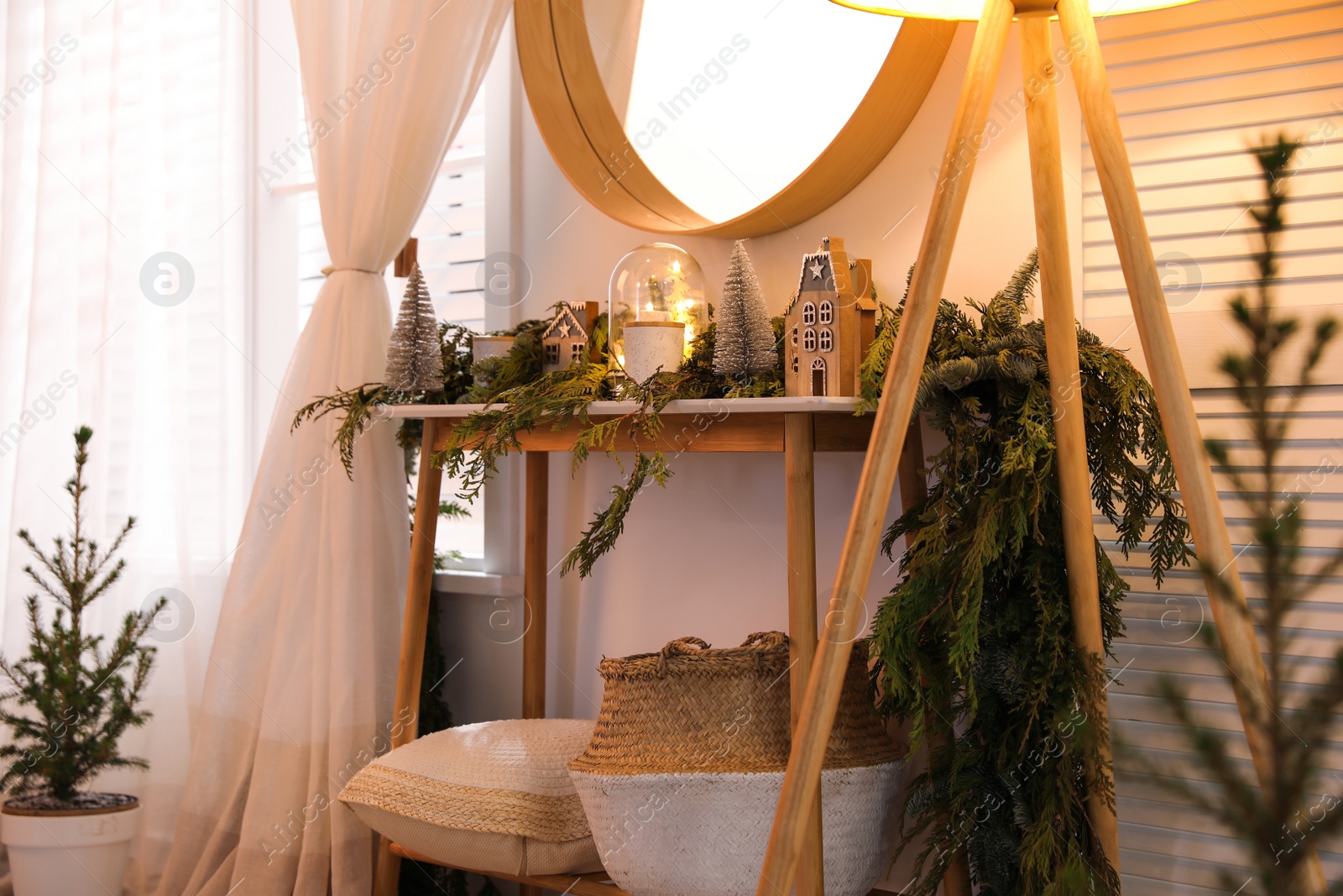 Photo of Wooden console table with Christmas decor near wall in room. Interior design