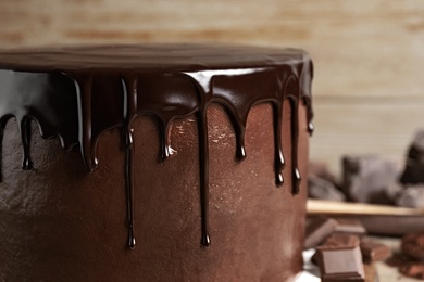 Photo of Freshly made delicious chocolate cake against blurred background, closeup