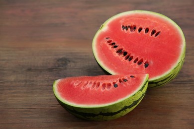 Photo of Delicious cut ripe watermelons on wooden table. Space for text