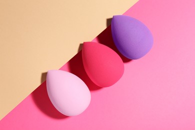 Photo of Many different makeup sponges on color background, flat lay