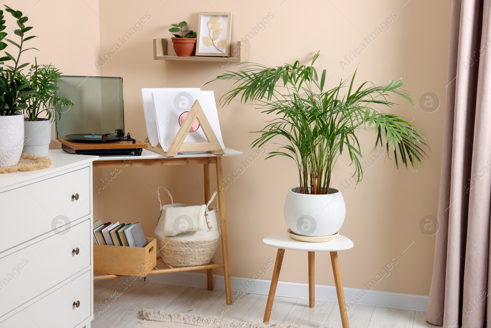 Photo of Stylish turntable with vinyl record on console table in cozy room