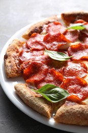 Photo of Tasty pepperoni pizza with basil on table, closeup