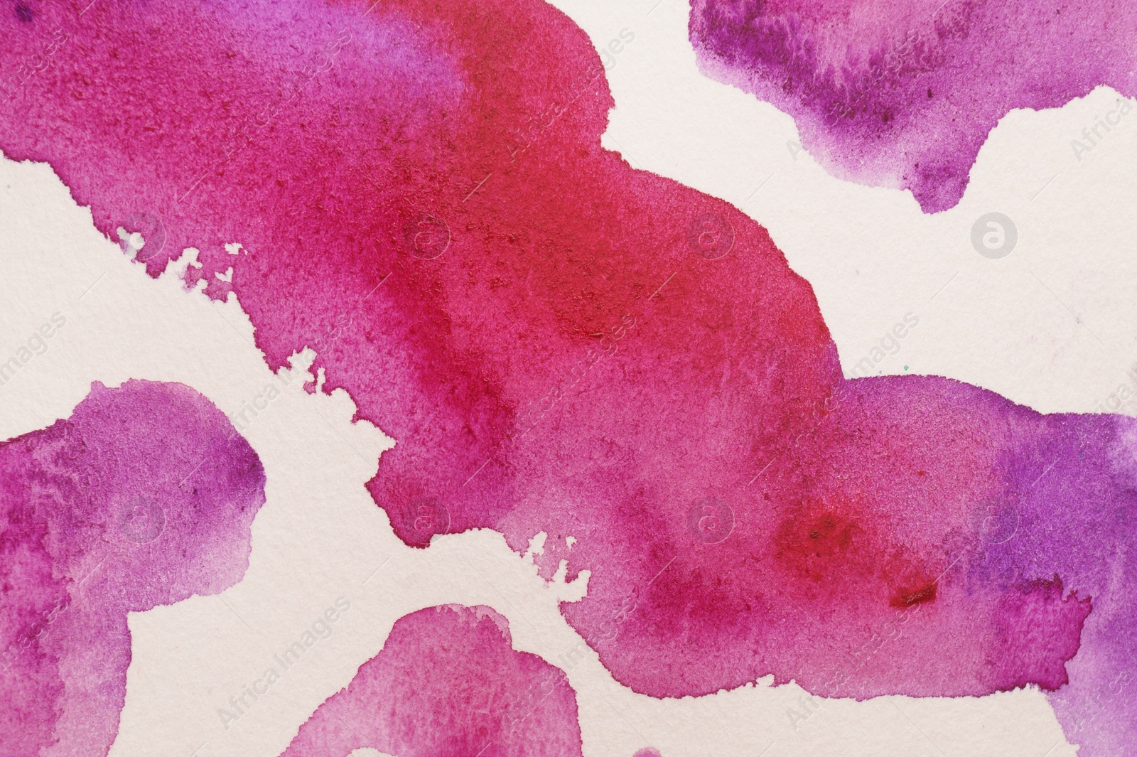 Photo of Blot of colorful watercolor paint on white paper, top view