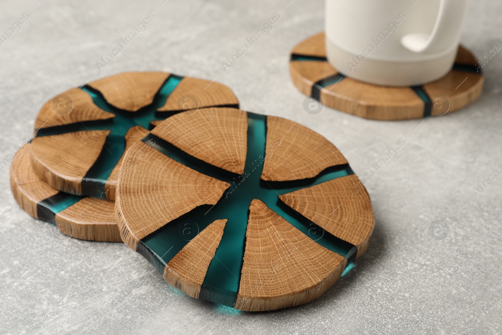 Photo of Stylish wooden cup coasters on light grey table