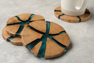 Stylish wooden cup coasters on light grey table