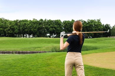 Photo of Woman playing golf on green course. Sport and leisure