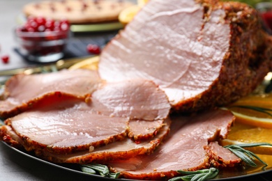 Delicious ham served for festive dinner on grey table, closeup