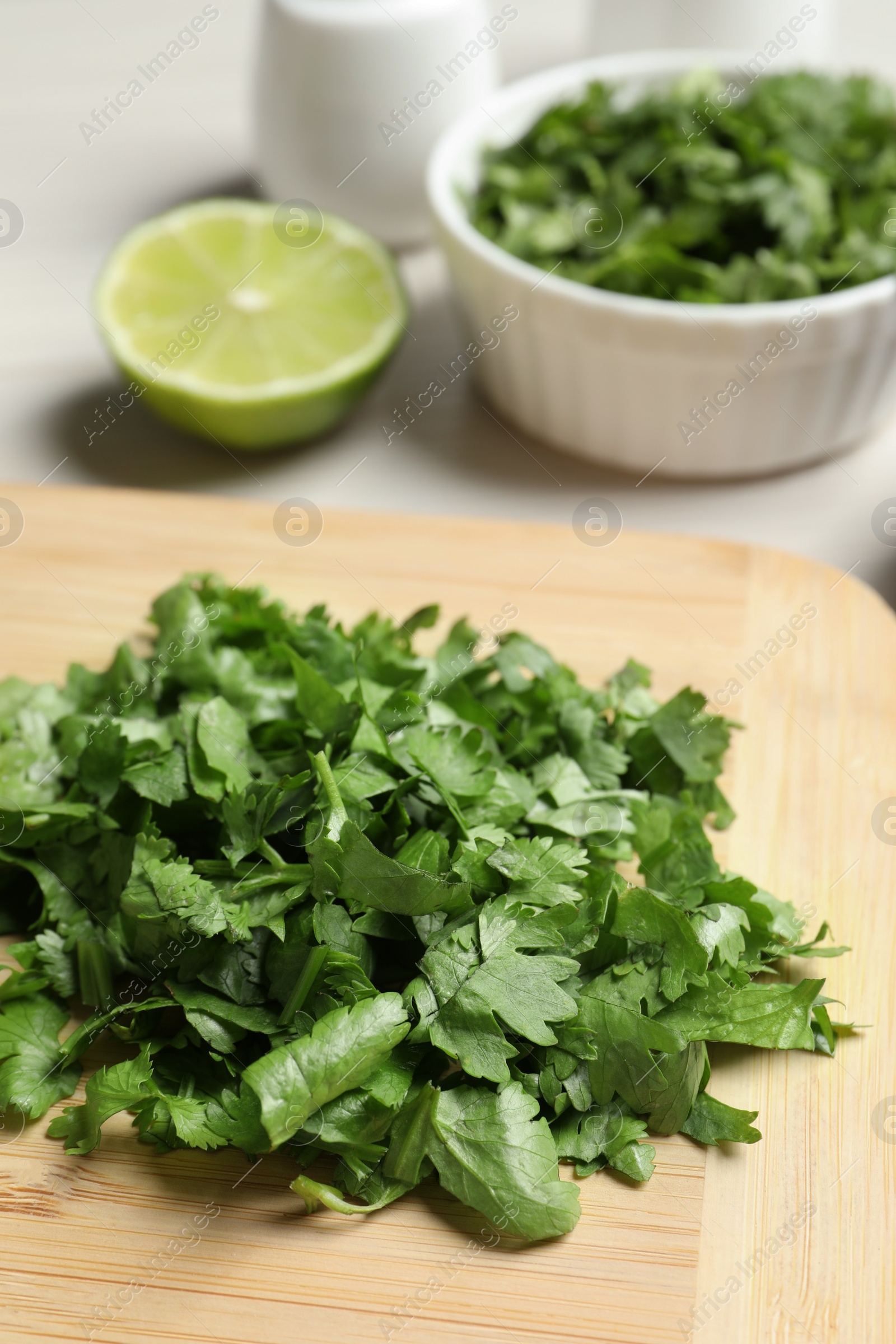 Photo of Raw green organic cilantro on wooden board, closeup