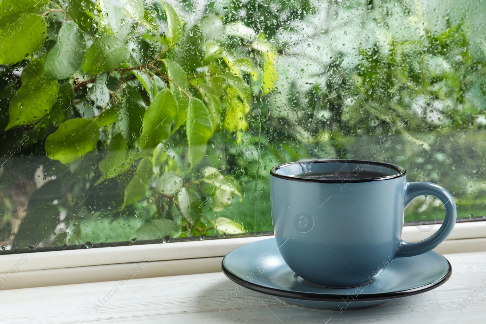 Photo of Cup of hot drink on windowsill, space for text. Rainy weather