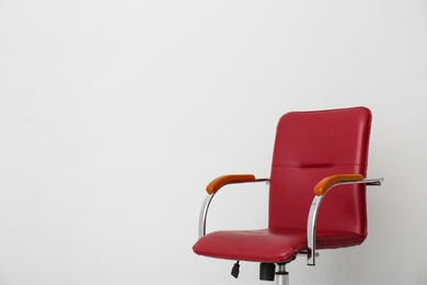 Photo of Comfortable office chair on light background. Space for text