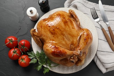 Photo of Tasty roasted chicken served on grey textured table, flat lay